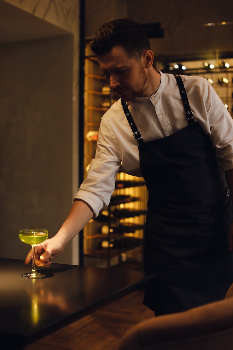 Photo by cottonbro studio A Man Putting a Cocktail Drink on the Table